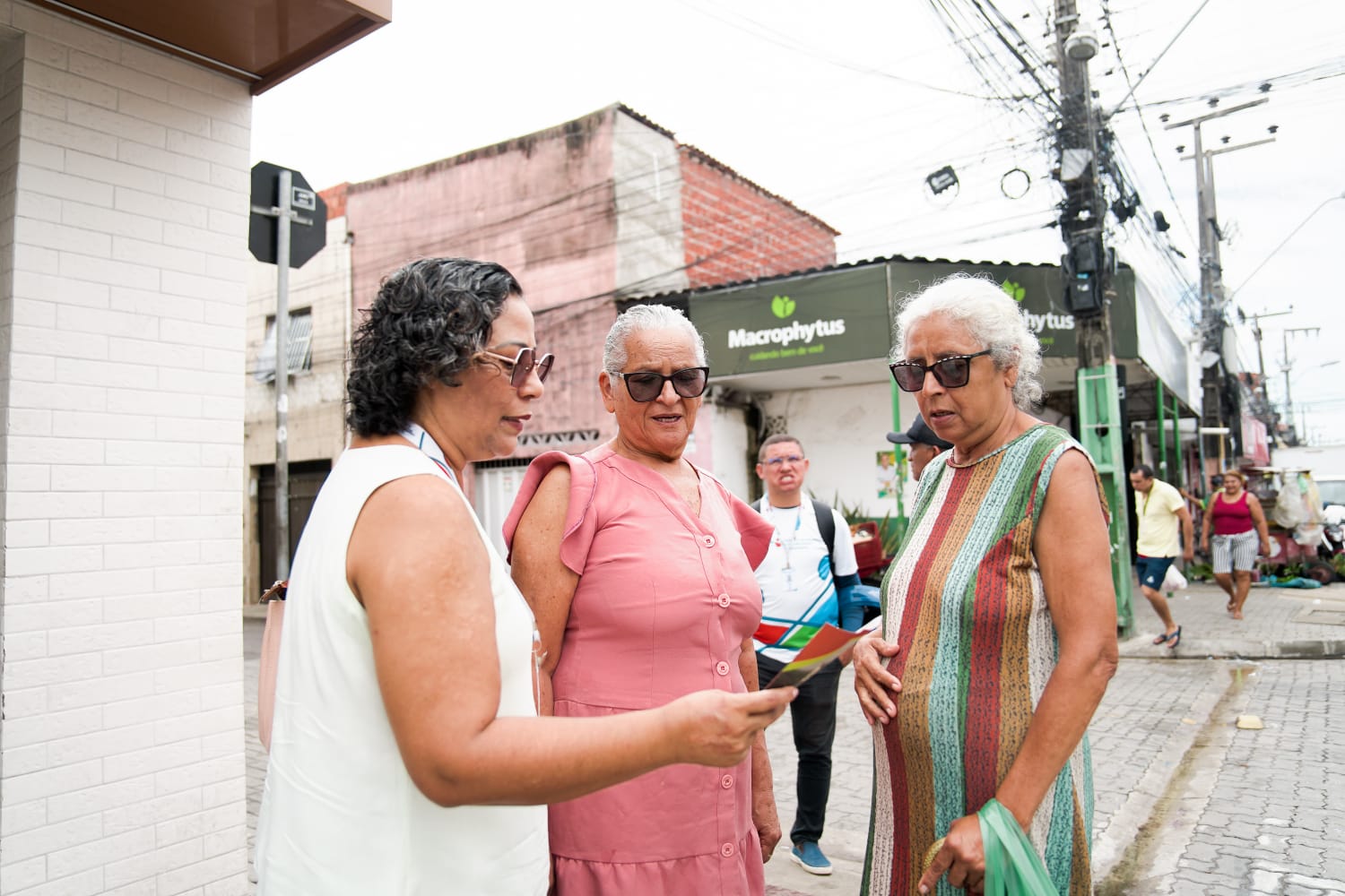 três mulheres conversando na avenida